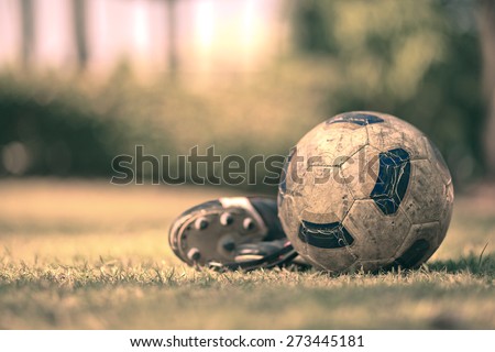 Soccer shoes & football on the green grass-Filtered Image