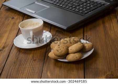 computer a cup of coffee and cookies