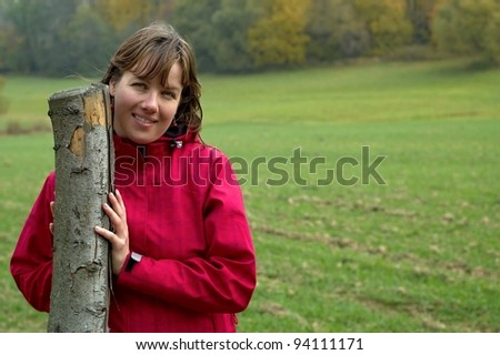 Young brunette woman adhering to wooden post