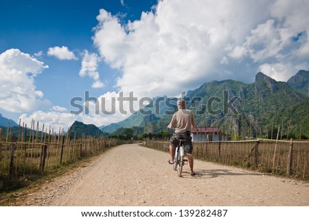 Man On Bike Standing On Road