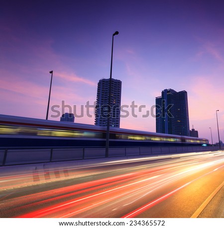The light trails on The Road with the modern building