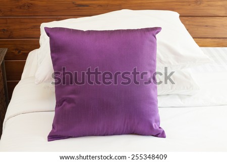 Purple cushion and pillow on bed