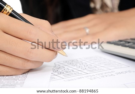 woman\'s hand writing with pen and calculator isolated on white background