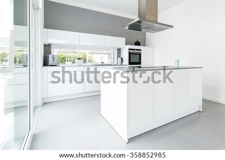 Interior of white kitchen with big windows