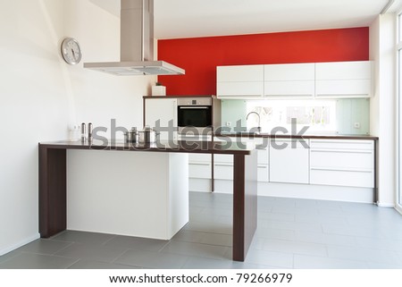 Modern white kitchen with red wall in the back