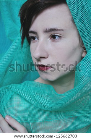 portrait photo of beauty pale model girl wrapped in green fabric close up in studio with studio light