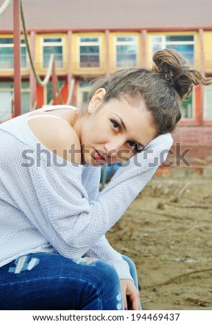 portrait of casual dressed girl with hair bun in city background