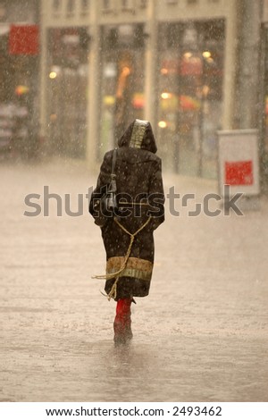 A womman is walking alone in the rain.