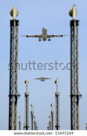 Planes are flying over landing lights in an airport