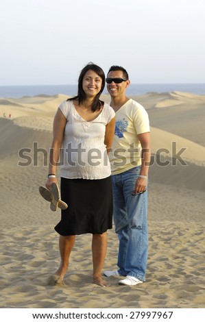 Happy couple on vacation. The woman is 4 month pregnant.