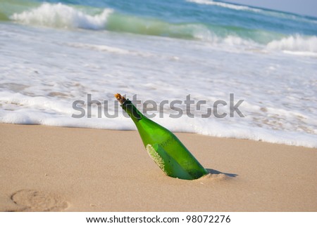 glass bottle on the beach with a sheet of paper inside