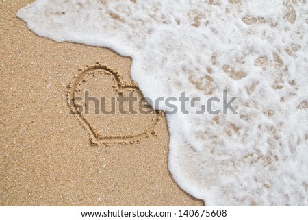 hearts drawn on the sand of a beach