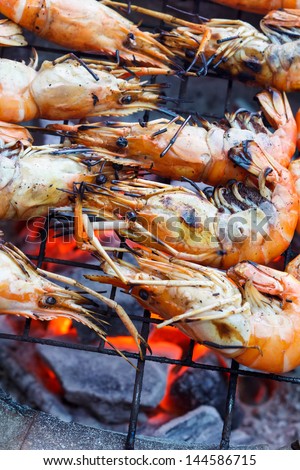 Grilled prawns on flaming grill.