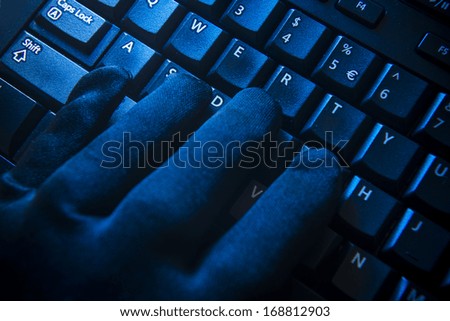 Black glove on computer keyboard