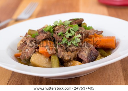 braised beef pot roast stew with vegetables on table