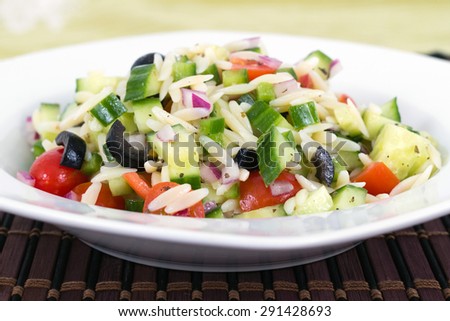 Mediterranean greek orzo pasta salad with black olive, red onion and cucumber