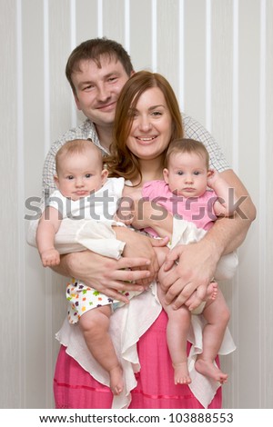 Young happy smiling family with twin baby girls