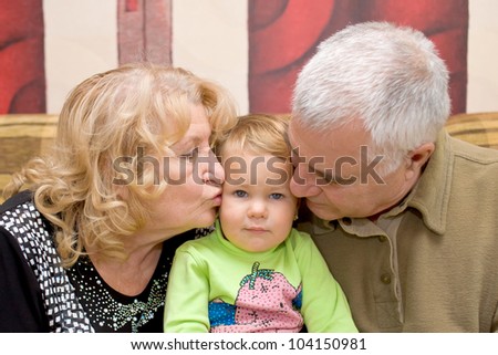 Grandparents - adorable amorous happy senior couple kissing baby