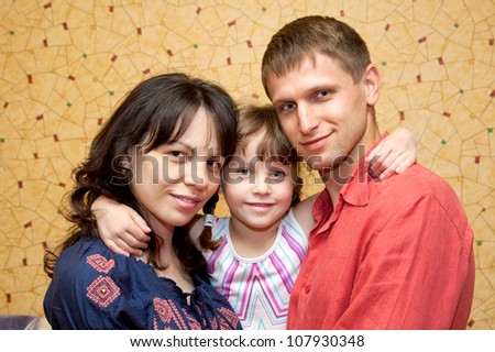 Father, mother and daughter hugging and smiling. Happy family.