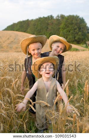 Three brothers funny playing field of wheat. The two older boys - twins. Smiling big family. Happy family concept. Summer holiday.