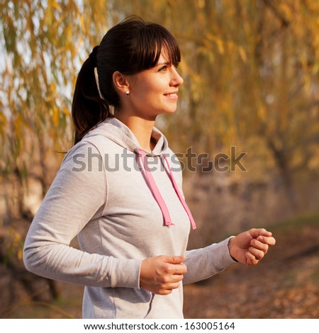 Happy middle-aged woman running in the sunlight at sunset. Healthy lifestyle concept.