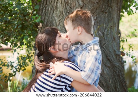 Mother and son kissing outdoor. Happy family concept.