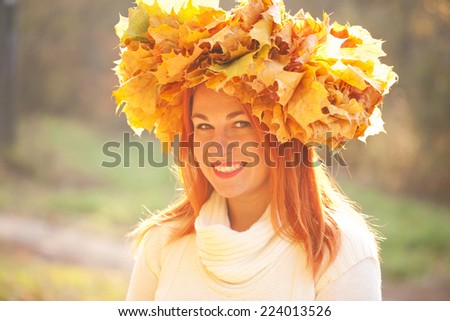 Autumn portrait. Young woman with crown of fall maple leaves
