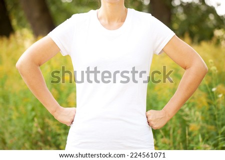 Young woman in white t-shirt outdoors. Ready for your text or symbol.