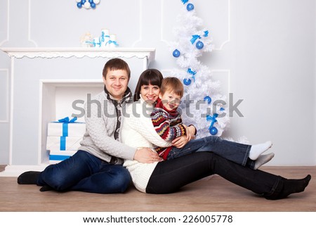 Happy family parents and kid with gifts near the Christmas tree. Christmas, New Year, holiday concept