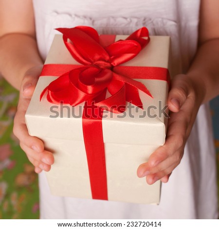 Kids hands holding a gift close-up. New Year, Christmas, mother\'s day, father\'s day, holiday concept.