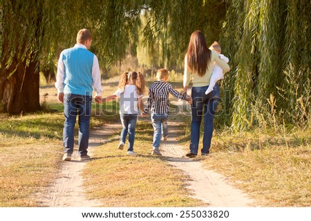 Big family walking in the park. Rear view. Family ties concept.