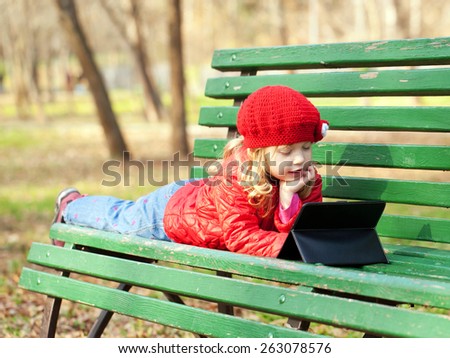 Kid with technology outdoors in the park