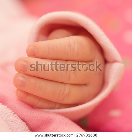 Little hand of a newborn baby. Selective soft focus on tiny fingers. Macro shot.