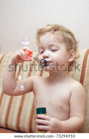 funny child is blowing soap bubbles