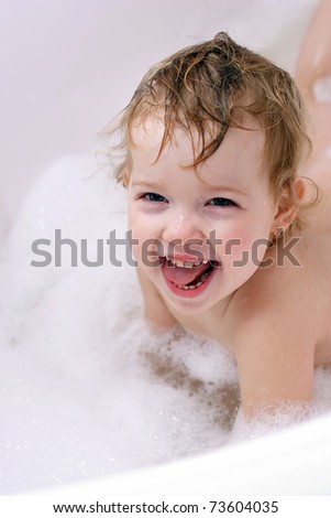 funny girl is swimming in bath