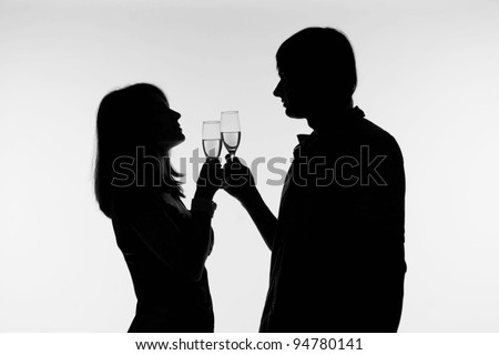 Silhouette of a happy couple with wine glasses as logo.