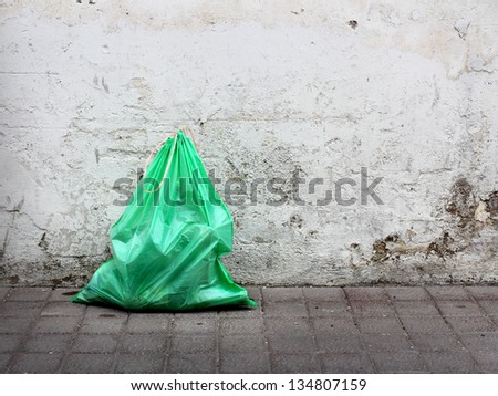 Green garbage bag on street