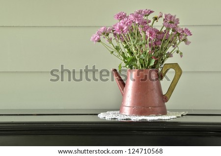 Purple flower in vintage vase on black piano