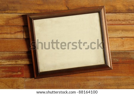Vintage wooden picture frame on the old wooden wall