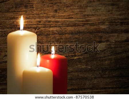 Three candles over a old wood background