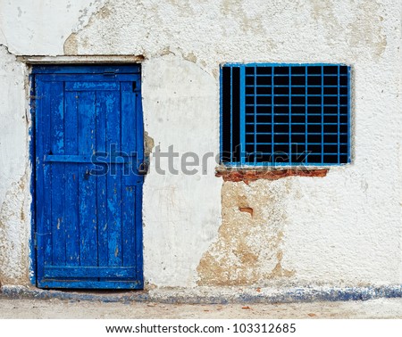 old house wall with blue door and window
