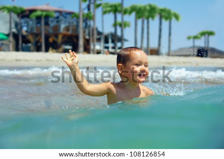happy baby boy enjoys swimming in sea waves. Crimea