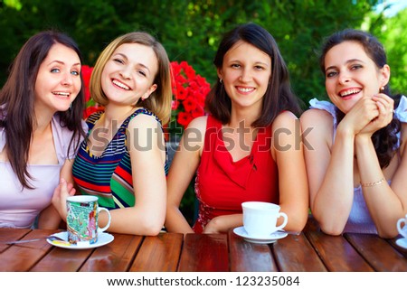 beautiful female friends in summer cafe