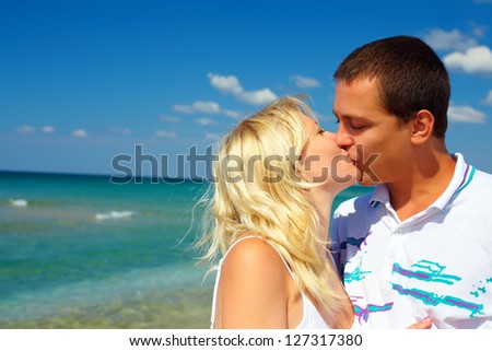 young couple in love kissing on beach