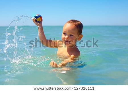 active baby playing water game in the sea