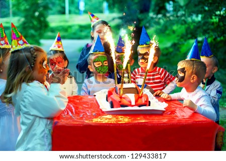 happy kids around birthday cake