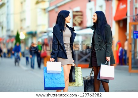 Beautiful Elegant Women Walking The Crowded City Street With Shopping Bags