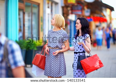 two beautiful women walking the city street