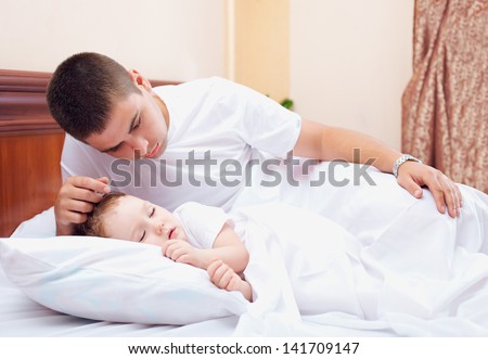 father watching the son sleeps, home indoors