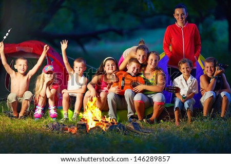 happy kids having fun around camp fire